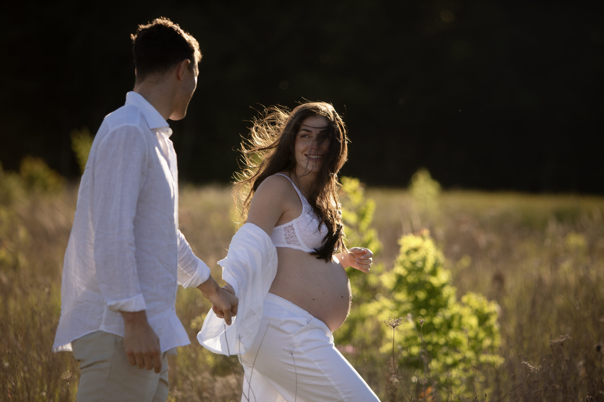 shooting grossesse en couple dans les champs. Echange de regards