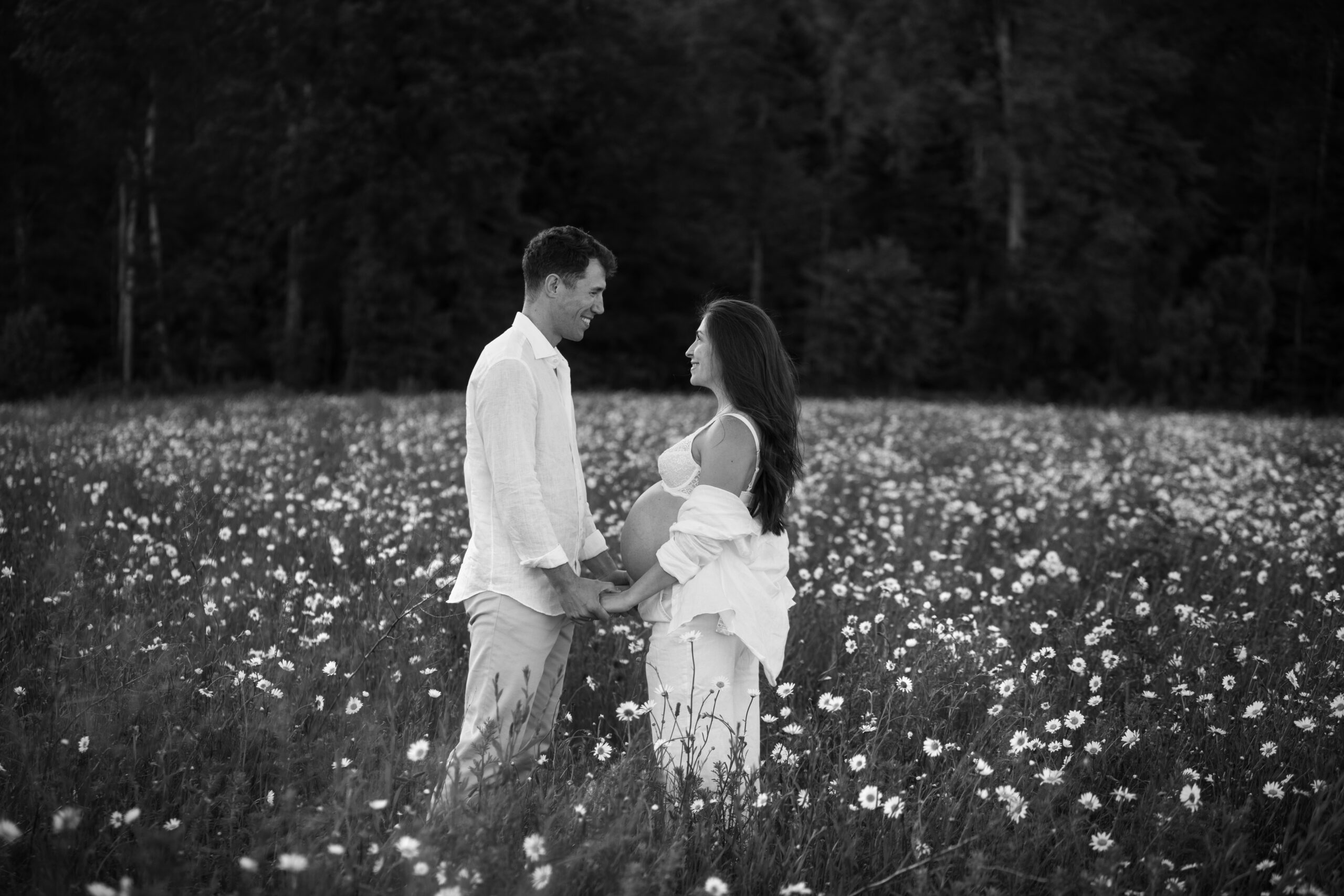 photo couple dans un champ de marguerite. Femme enceinte